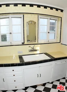 a kitchen with a checkered floor and white cabinets