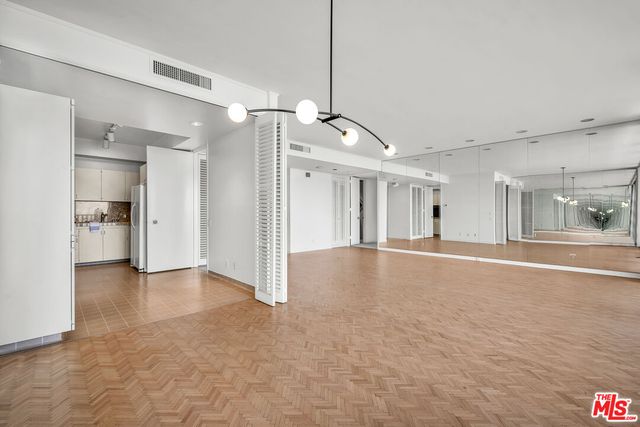 a kitchen with a refrigerator and white cabinets