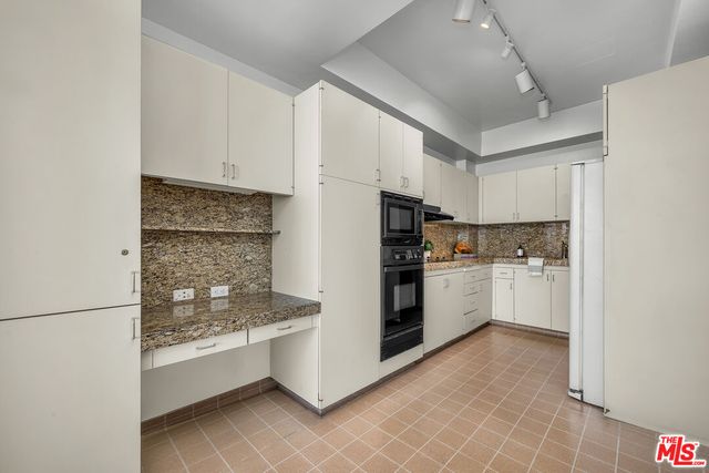 a kitchen with stainless steel appliances granite countertop a sink a stove and cabinets