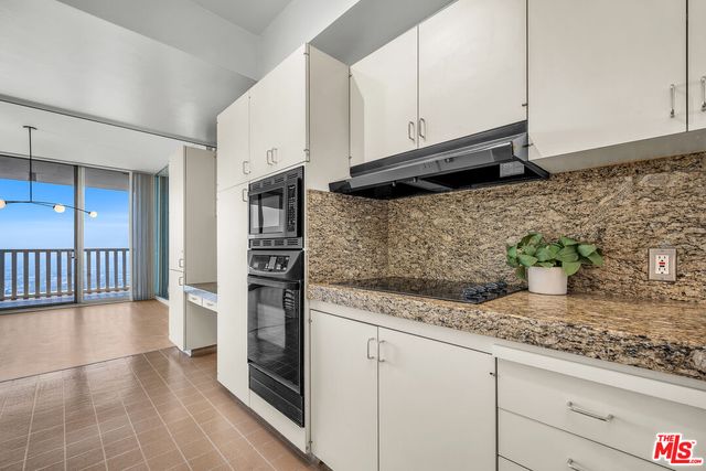 a kitchen with a sink a stove and cabinets