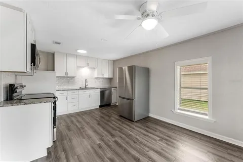 a kitchen with a refrigerator a sink and dishwasher with wooden floor