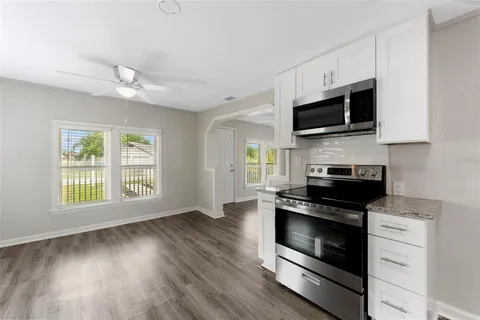 a kitchen with a stove a microwave and window