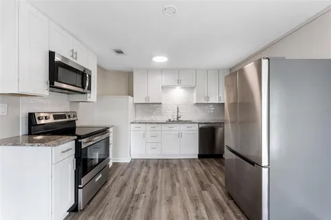 a kitchen with a refrigerator stove top oven and sink