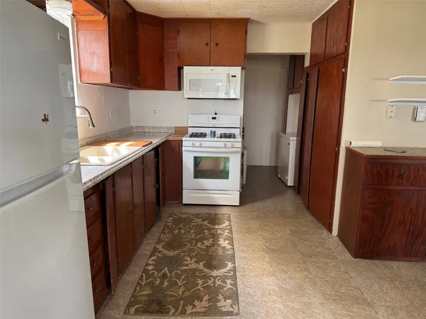 a kitchen with stainless steel appliances granite countertop a refrigerator and a stove
