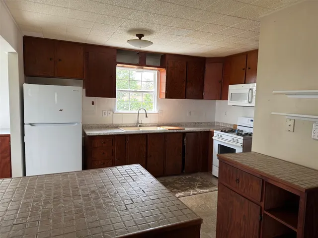 a kitchen with granite countertop a sink stainless steel appliances and cabinets