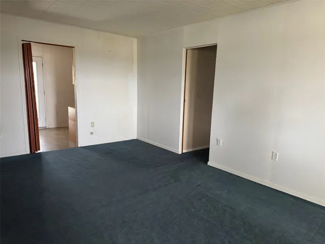 an empty room with closet and mirror