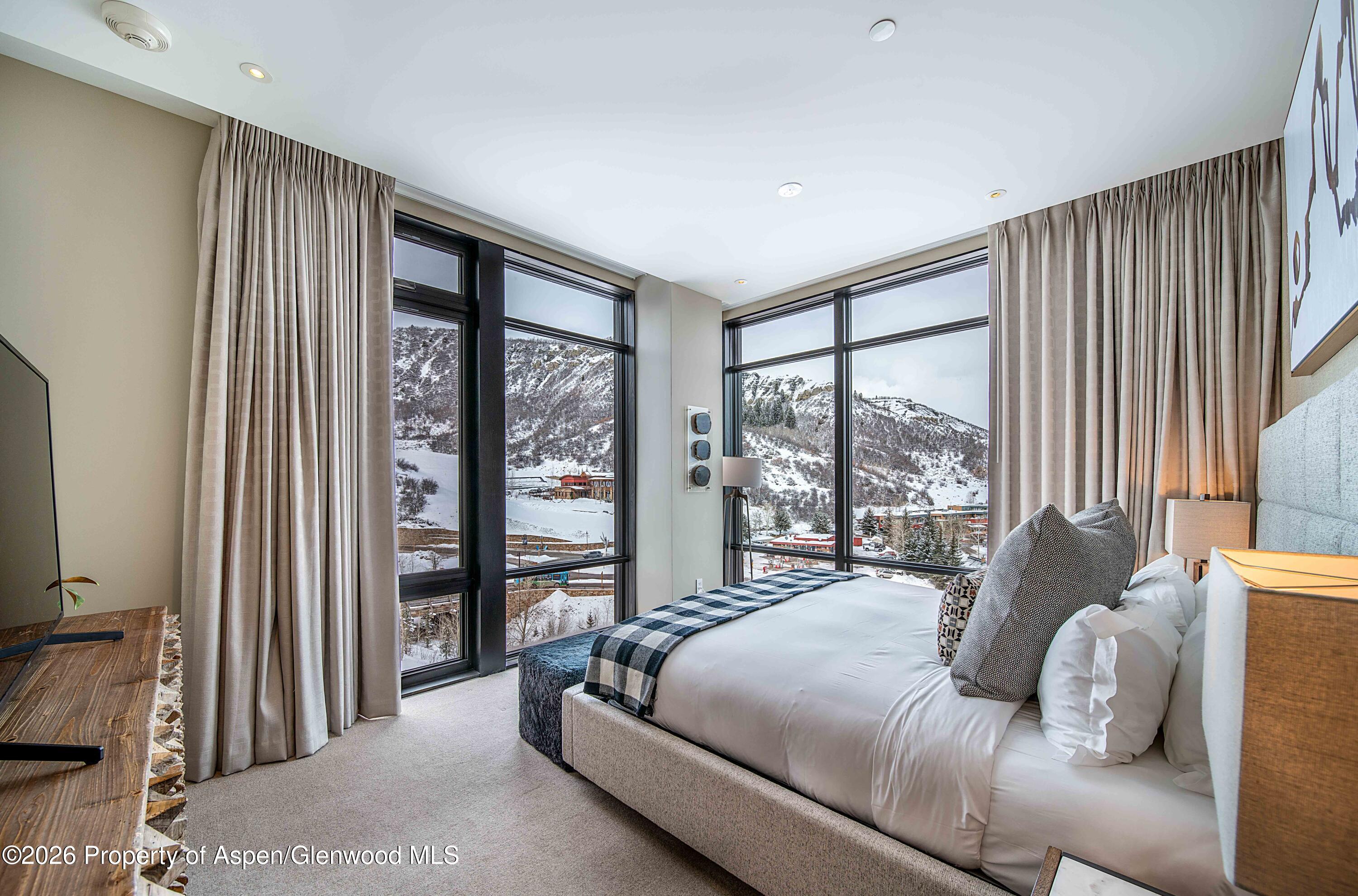 77 Wood Road, Unit 50711 Snowmass Village, CO 81615 - Photo 5 of 20 a bedroom with a bed and a large window