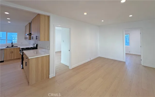 a kitchen with a sink cabinets and wooden floor