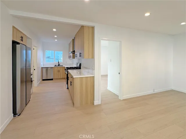 a view of kitchen with stainless steel appliances refrigerator stove microwave and cabinets