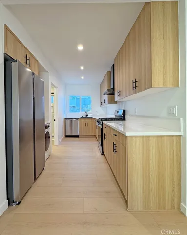a large kitchen with stainless steel appliances lots of counter space and a sink