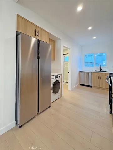 a kitchen with a refrigerator a microwave and white cabinets