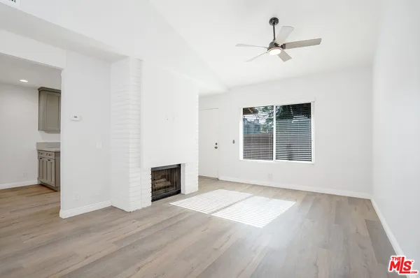 a view of a livingroom with wooden floor and a ceiling fan