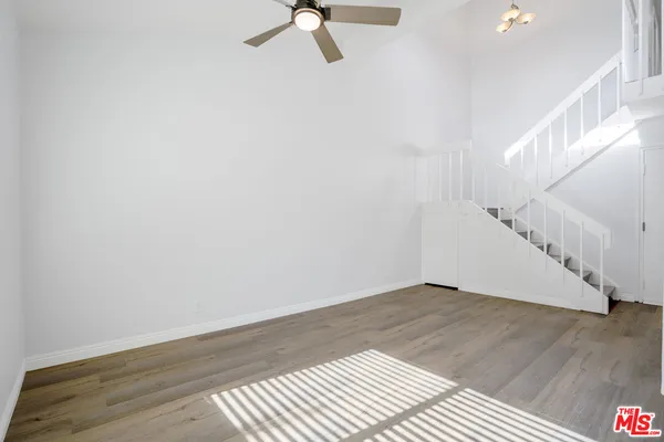 a view of a kitchen with wooden floor and a window