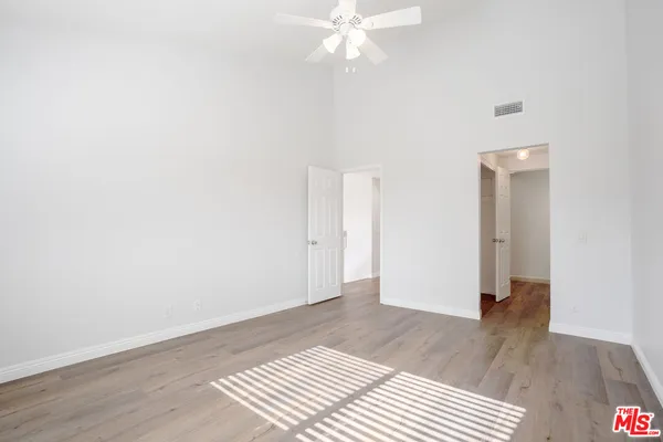 an empty room with a window and wooden floor