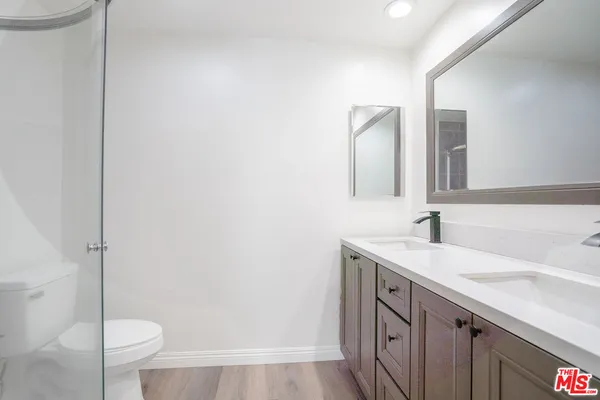 a bathroom with a granite countertop sink toilet and shower