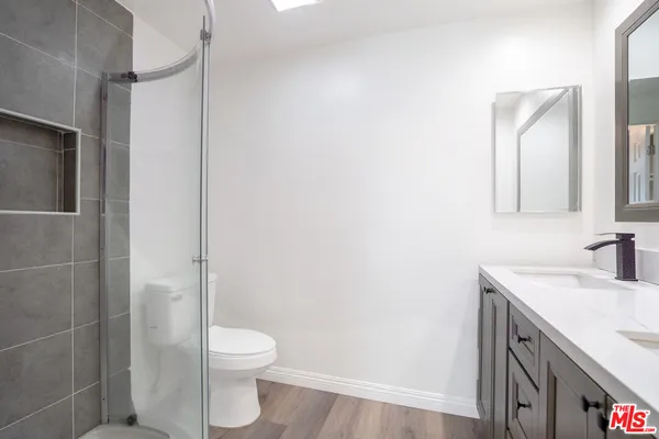 a bathroom with a sink a toilet and shower