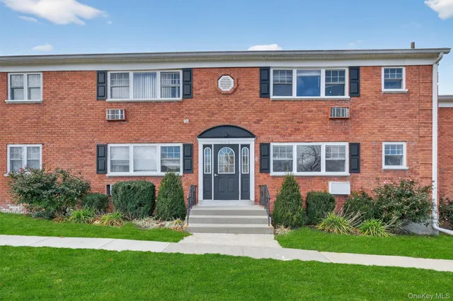 a front view of a house with garden and yard