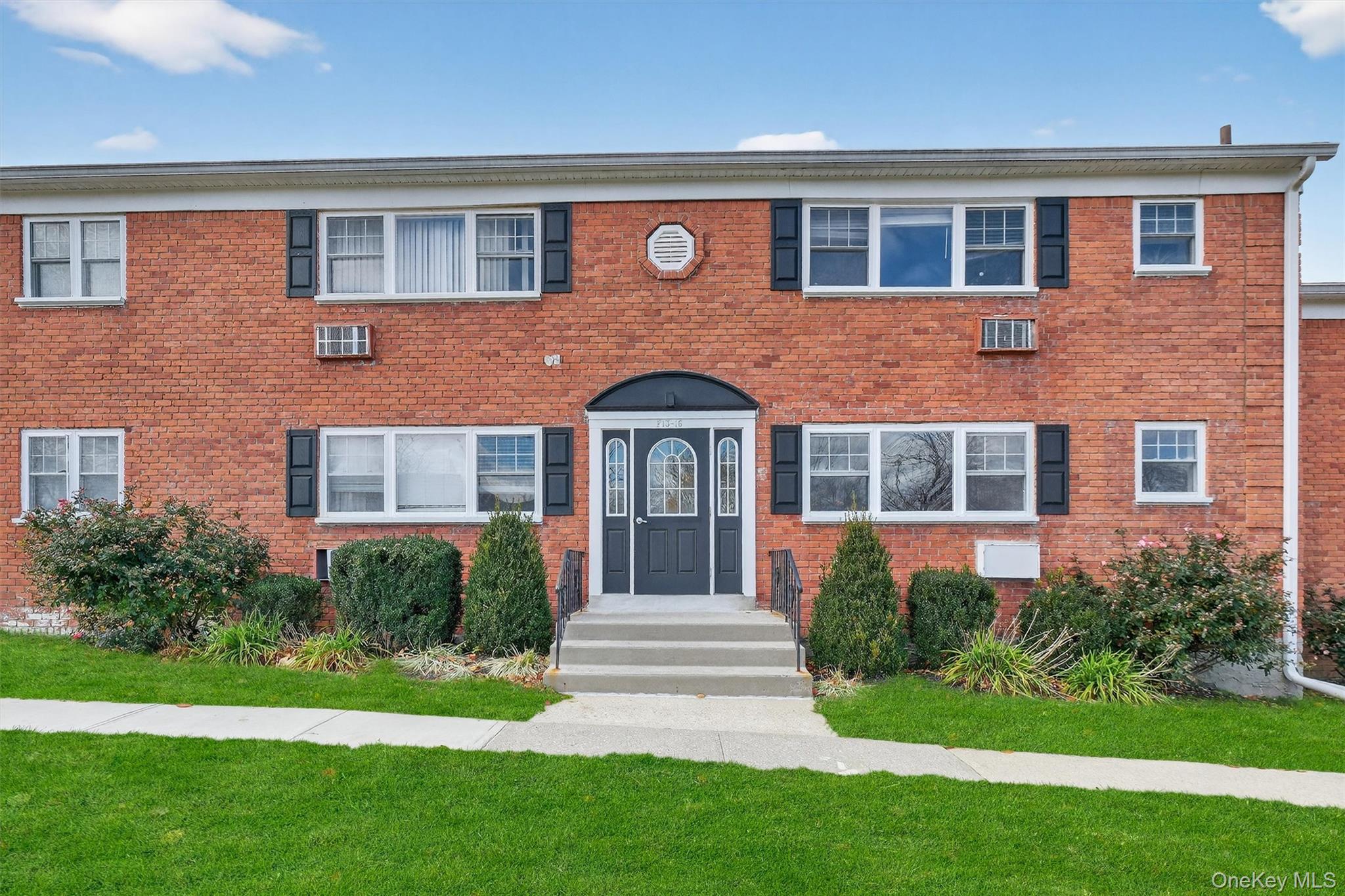 1879 Crompond Road, Unit F13 Peekskill, NY 10566 - Photo 2 of 24 a front view of a house with garden and yard