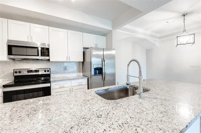 a kitchen with stainless steel appliances a stove a sink a microwave and refrigerator