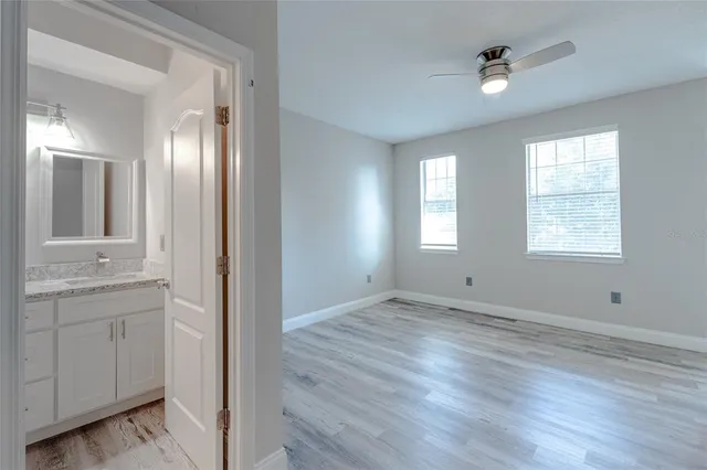 a view of an empty room with window and wooden floor