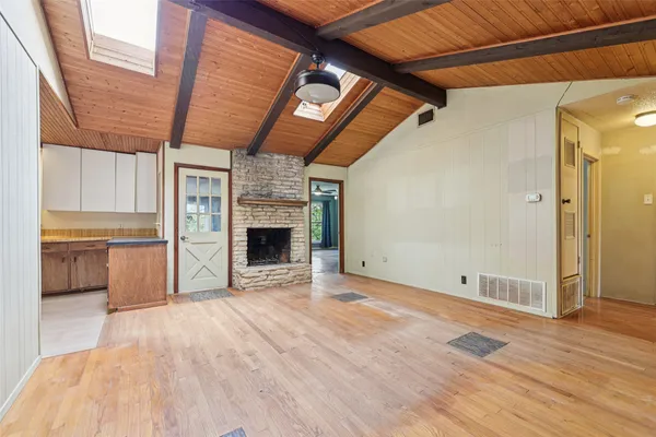 a view of an empty room with a fireplace and a window