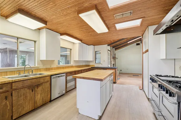 a view of a kitchen with stainless steel appliances granite countertop a sink and cabinets