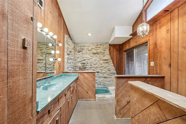 a bathroom with a granite countertop sink and shower