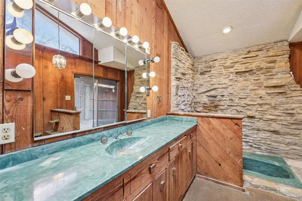 a bathroom with a granite countertop sink and a large mirror