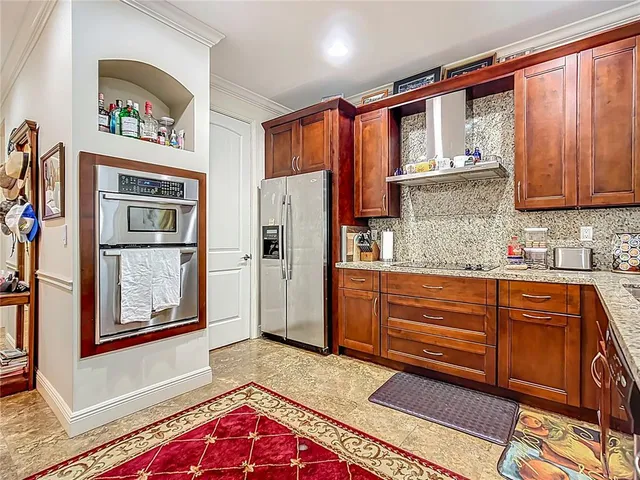 a kitchen with stainless steel appliances granite countertop a refrigerator and a stove top oven