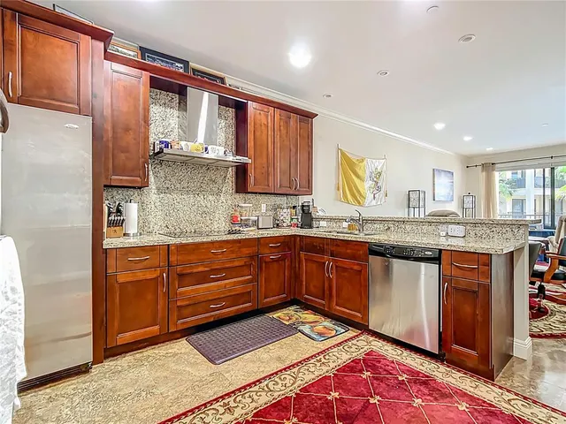 a kitchen with granite countertop wooden cabinets stainless steel appliances and a granite counter top