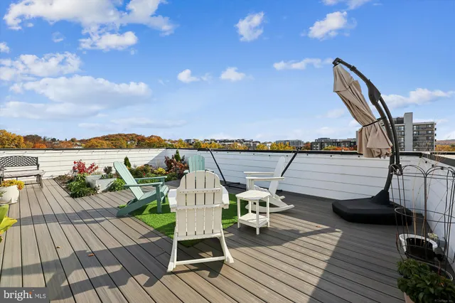 a view of a rooftop deck with chairs and ocean view
