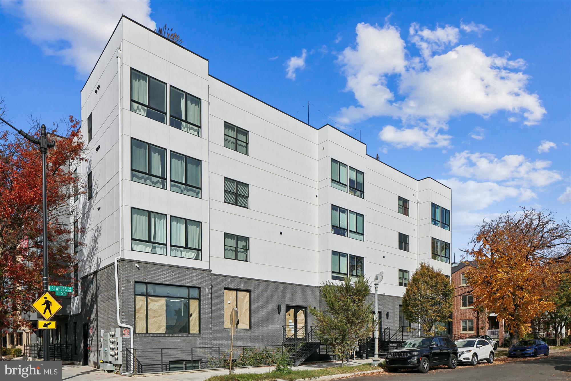 1102 Staples Street Northeast, Unit 301 Washington, DC 20002 - Photo 20 of 24 a front view of a building with lot of cars and trees