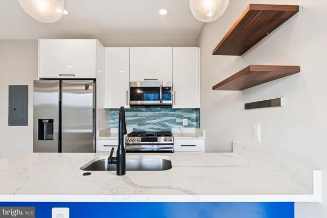 a kitchen with stainless steel appliances kitchen island a refrigerator sink and stove