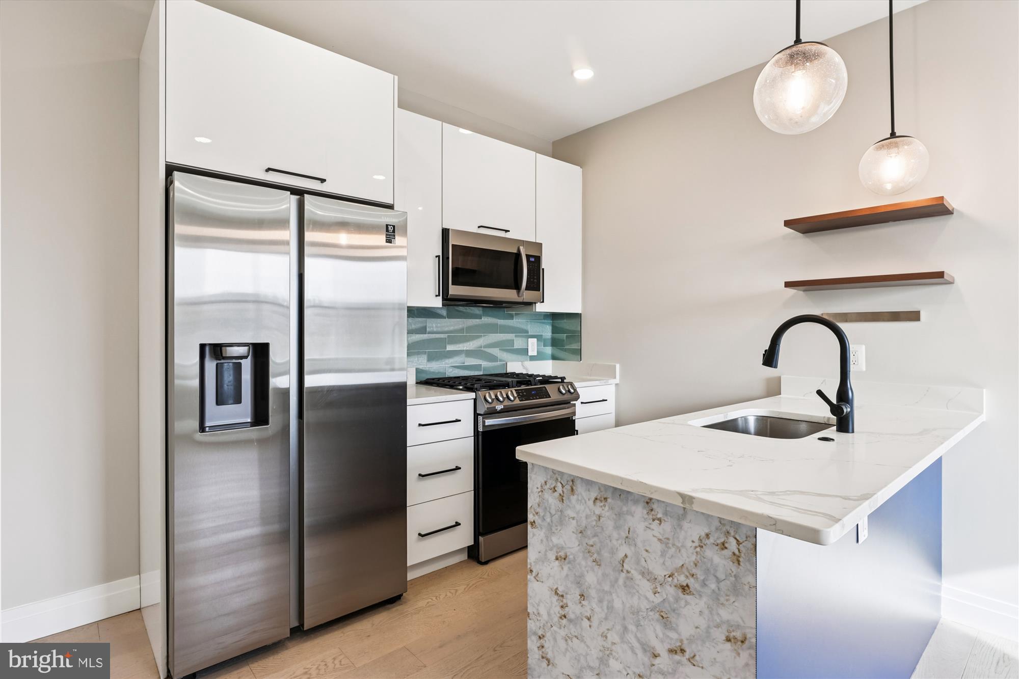 1102 Staples Street Northeast, Unit 301 Washington, DC 20002 - Photo 3 of 24 a kitchen with stainless steel appliances a refrigerator sink and microwave