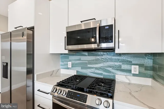 a kitchen with stainless steel appliances granite countertop a stove and a refrigerator