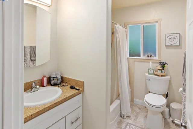 a bathroom with a granite countertop sink mirror vanity and toilet