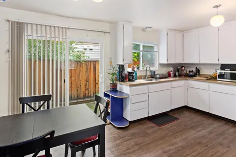 a kitchen with a sink a window and chairs