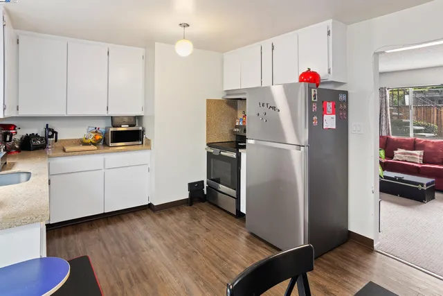 a kitchen with a refrigerator and white cabinets