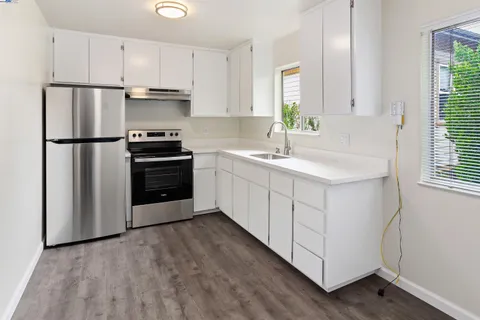 a kitchen with white cabinets and white appliances