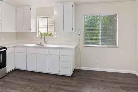 a kitchen with a sink cabinets and a window