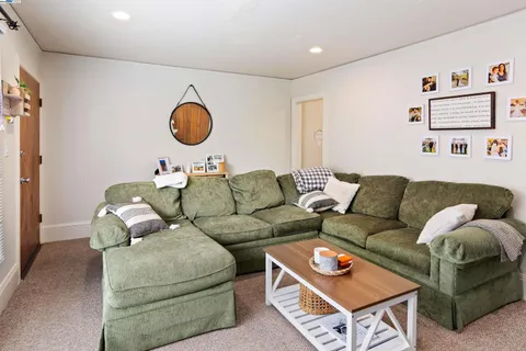 a living room with furniture and a air conditioner vent