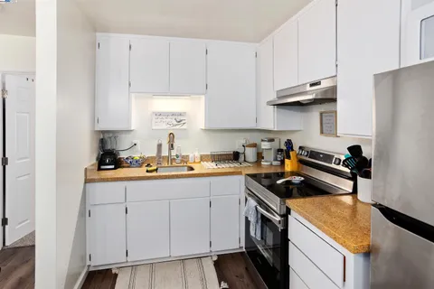 a kitchen with cabinets appliances a sink and a counter top