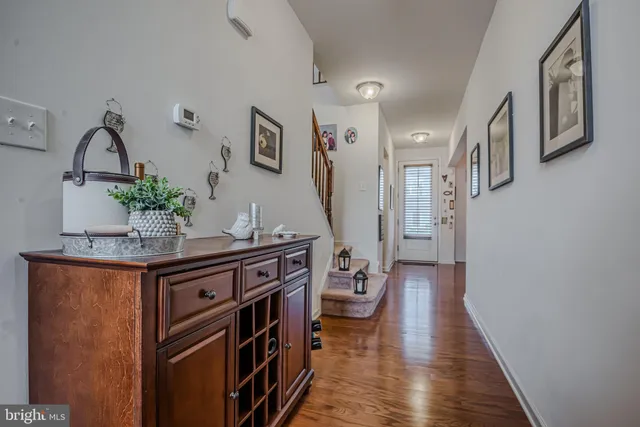 a kitchen with stainless steel appliances granite countertop a stove top oven a sink dishwasher a dining table and chairs with wooden floor