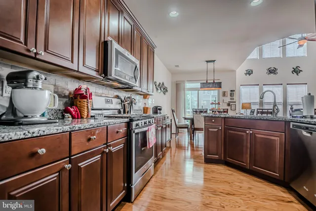 a dining room with furniture a chandelier and wooden floor