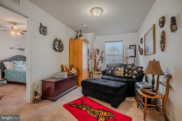 a bedroom with a bed and a lamp on dresser