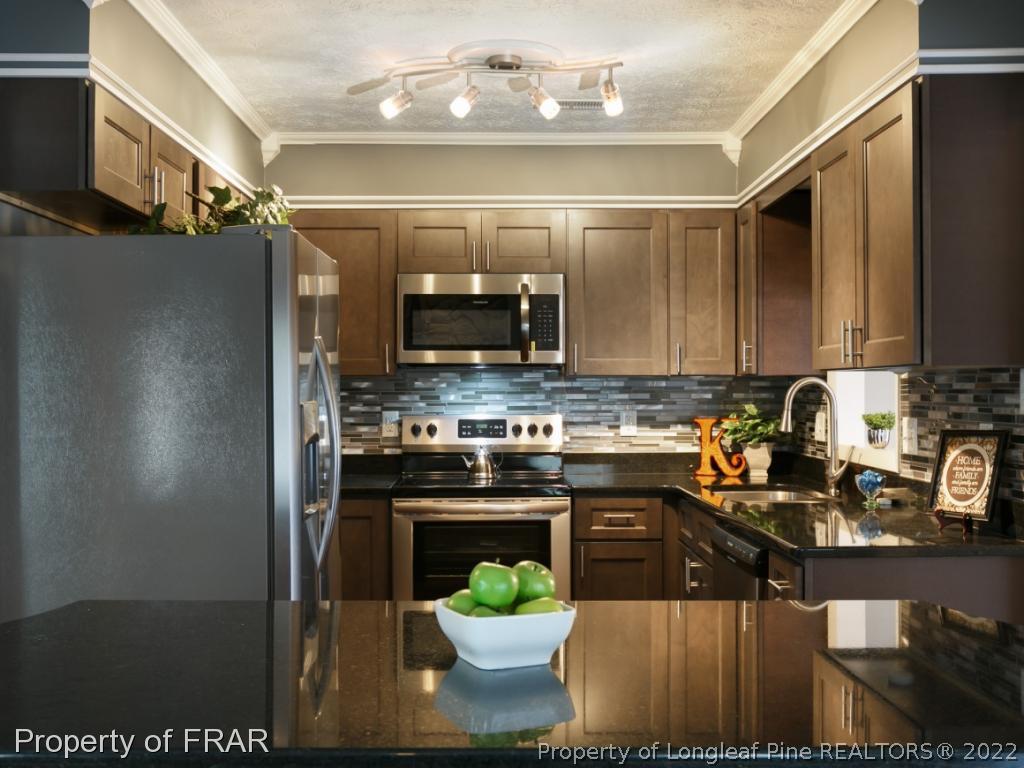 1007 Landau Road Fayetteville, NC 28311 - Photo 12 of 34 a kitchen with stainless steel appliances granite countertop a refrigerator a stove and a sink