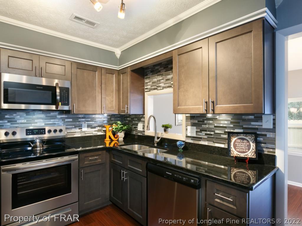 1007 Landau Road Fayetteville, NC 28311 - Photo 13 of 34 a kitchen with stainless steel appliances a stove sink microwave and cabinets