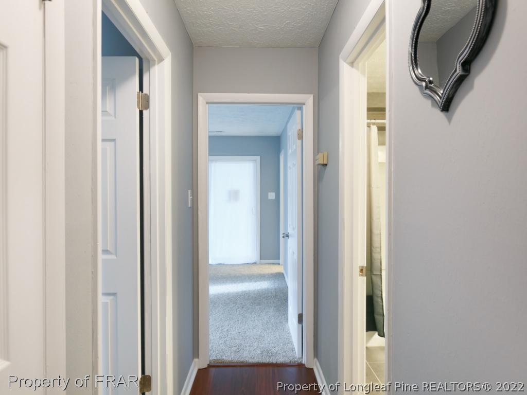 1007 Landau Road Fayetteville, NC 28311 - Photo 21 of 34 a view of a hallway with wooden floor windows and a bathroom
