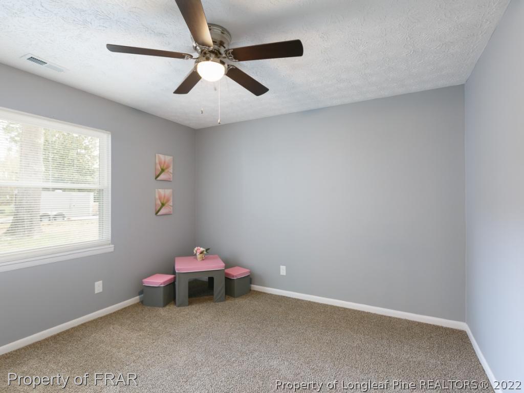 1007 Landau Road Fayetteville, NC 28311 - Photo 23 of 34 a room with a chandelier fan and a window