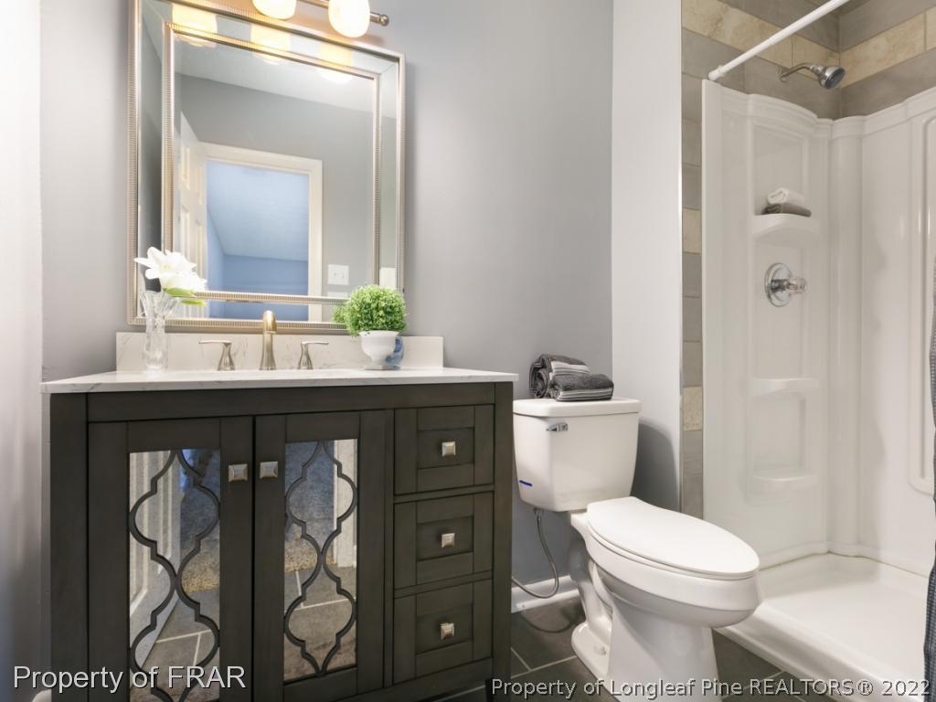 1007 Landau Road Fayetteville, NC 28311 - Photo 27 of 34 a bathroom with a granite countertop toilet sink and mirror